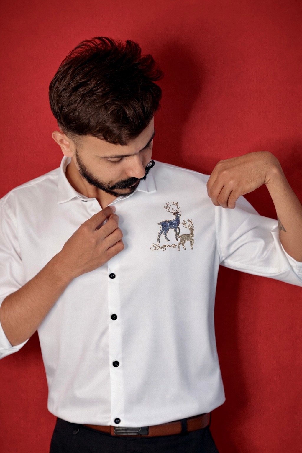 Man-inspects-embroidered-deer-design.jpeg